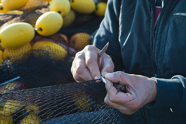 Fisherman repairing fishing net.